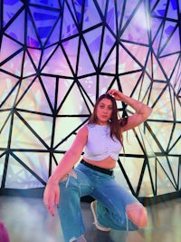 a woman posing in front of a geometric wall